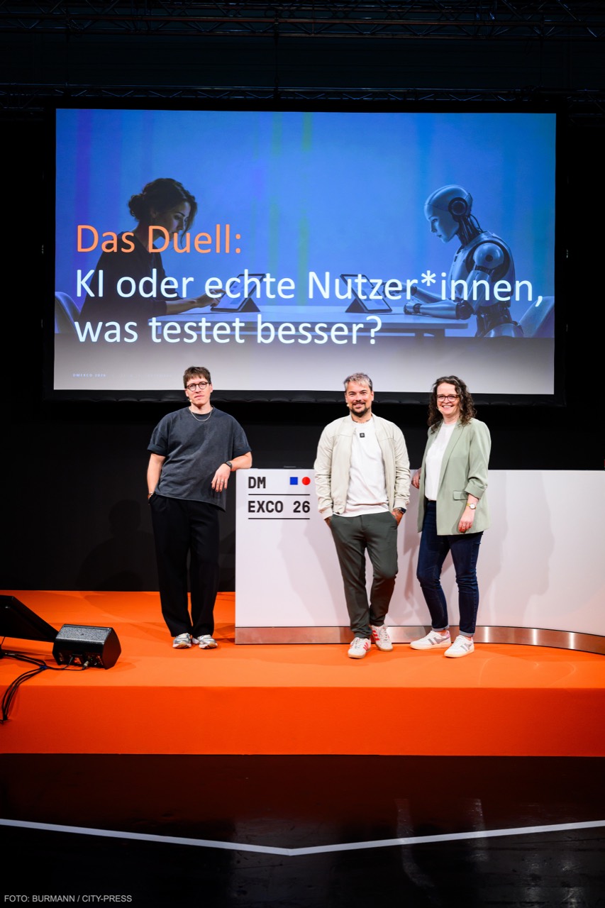 Simon Erdmann, Christoph Bordeck und Doris Henzler vor der Leinwand des Live-Duells